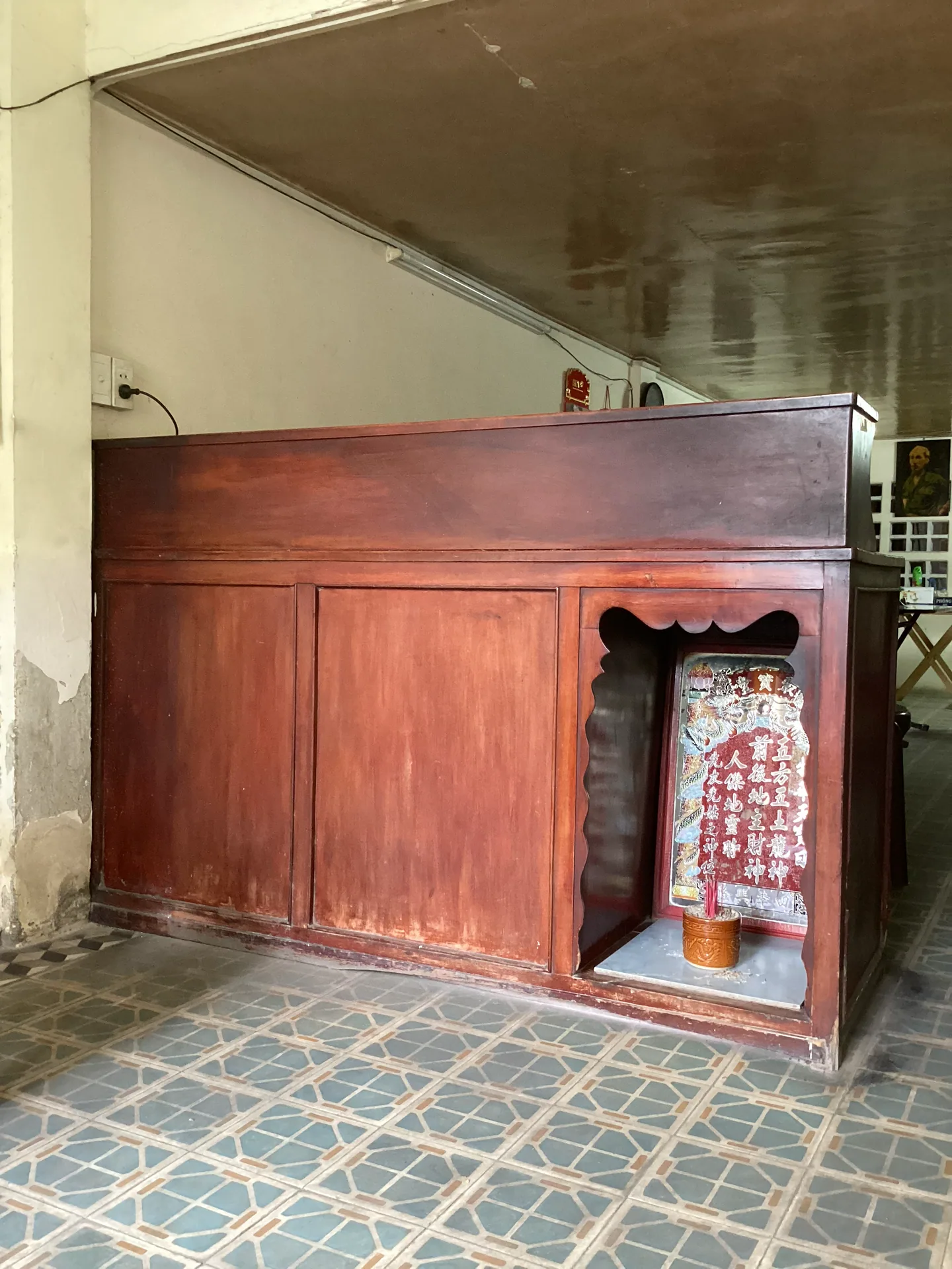 Tủ gỗ có khoang mở phía dưới, trưng bày trong không gian di tích.
