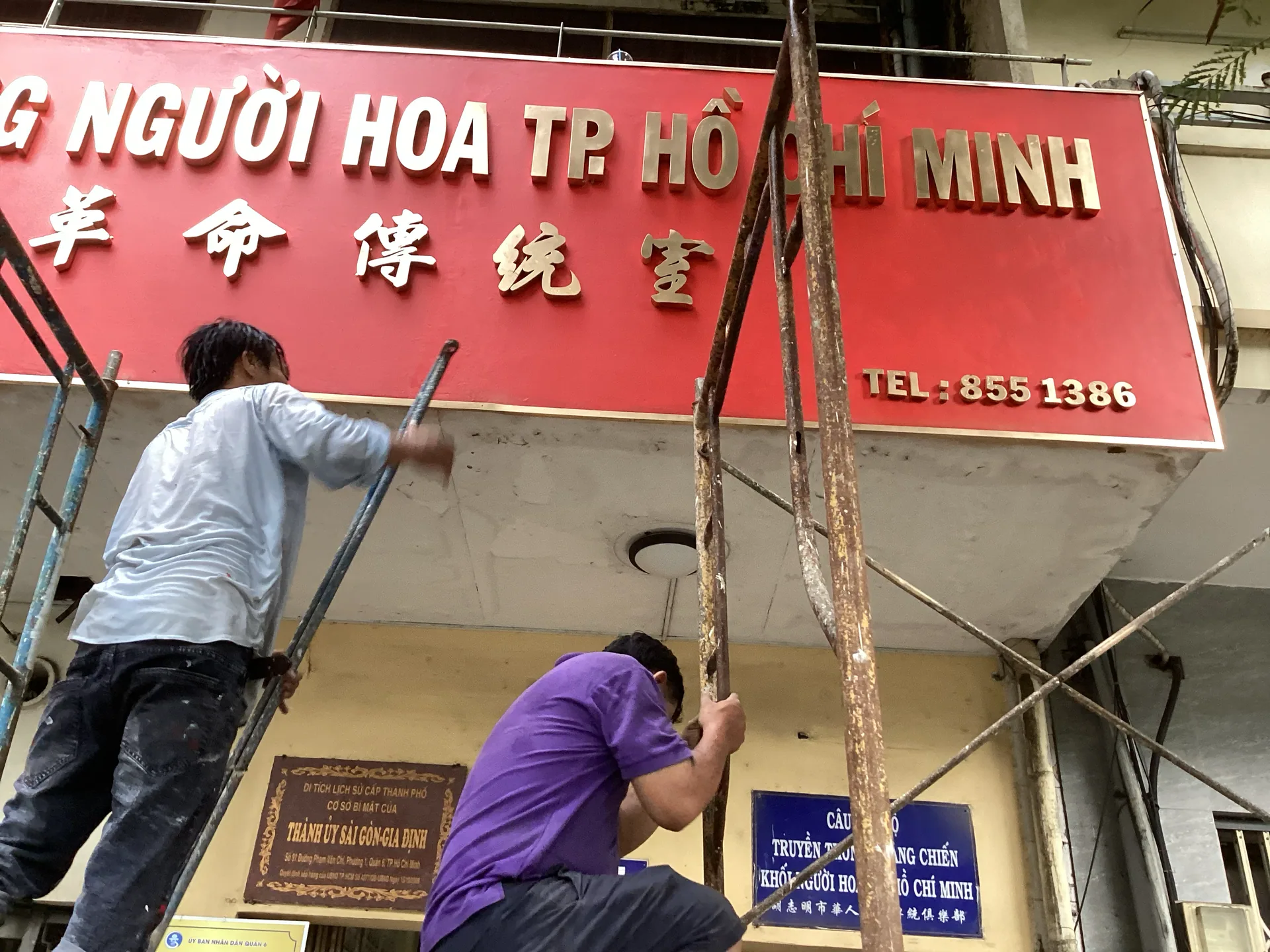 Nhân công đang lắp đặt, sửa chữa khu vực bảng hiệu và mặt tiền nhà di tích