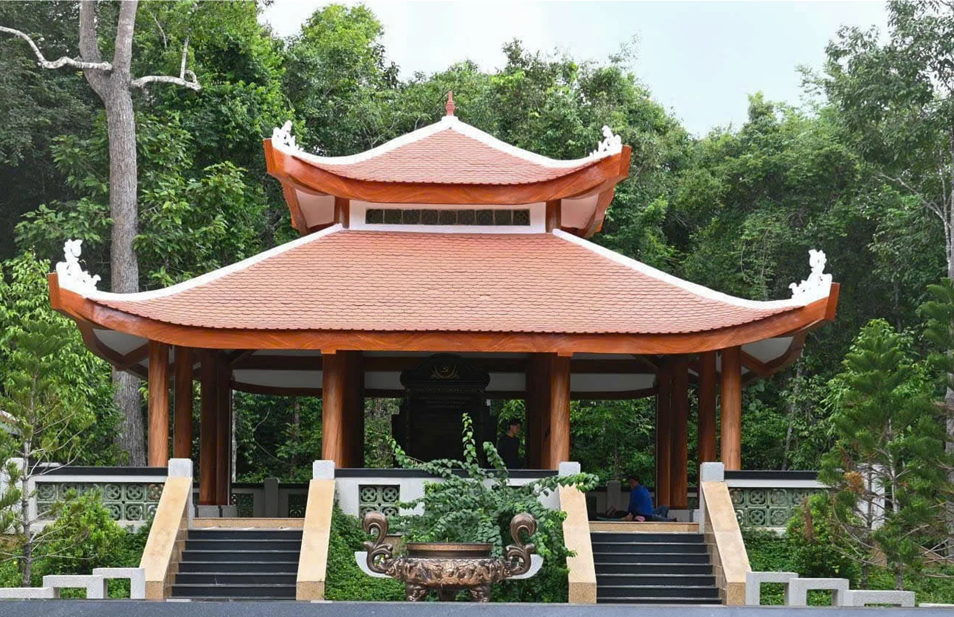 Mặt trước khu bia tưởng niệm giữa không gian cây xanh.